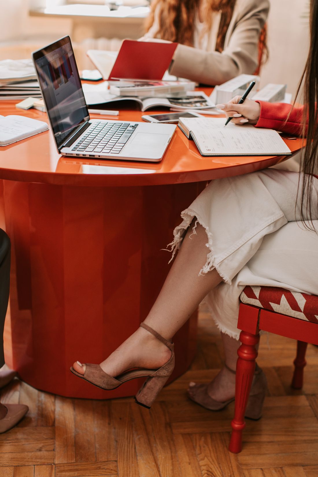 Women working with a laptop and handwritten notes.